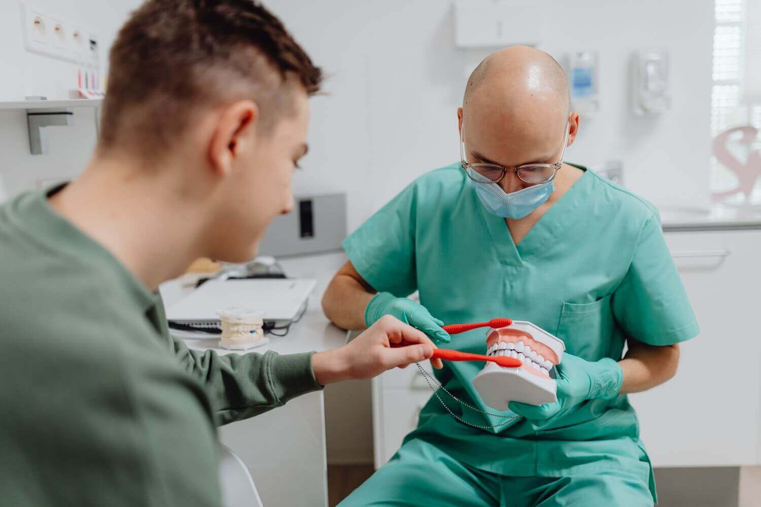 Odontoiatra spiega la tecnica di igiene orale con un modello